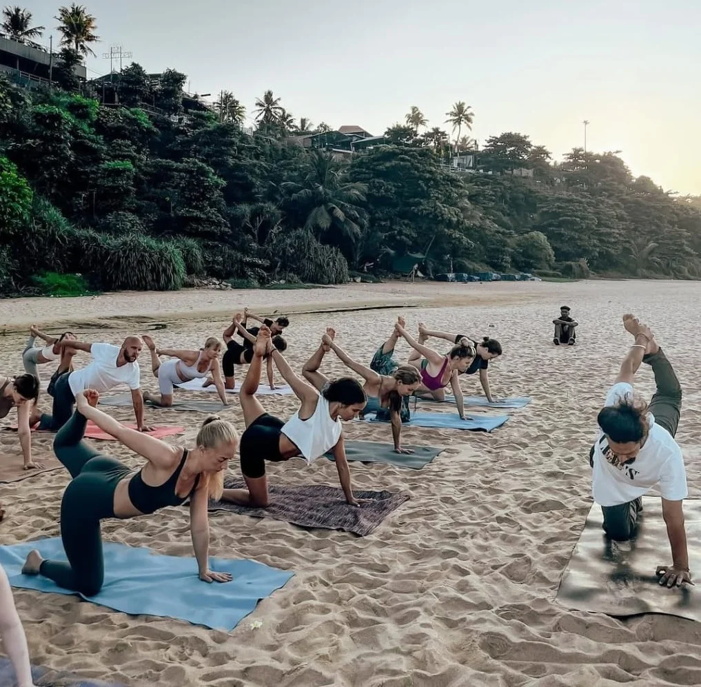 Yoga students practicing on the beach at Rishikul Yogshala in Kerala Yoga students practicing on the beach at Rishikul Yogshala in Kerala