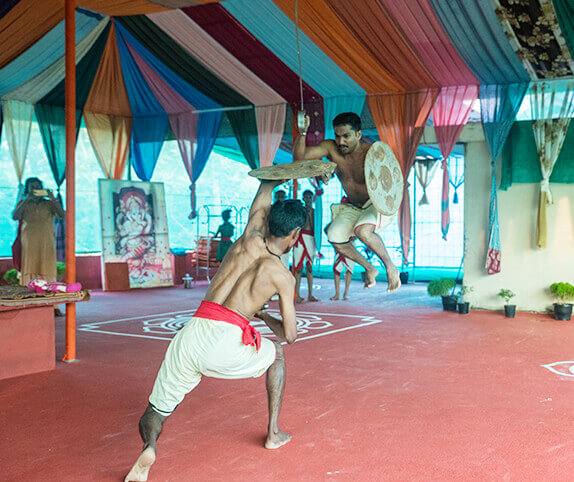 Kalaripayattu warriors performing an intense combat demonstration with shields and swords