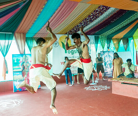 Kalaripayattu practitioners engaging in a dynamic martial arts duel at Rishikul Yogshala