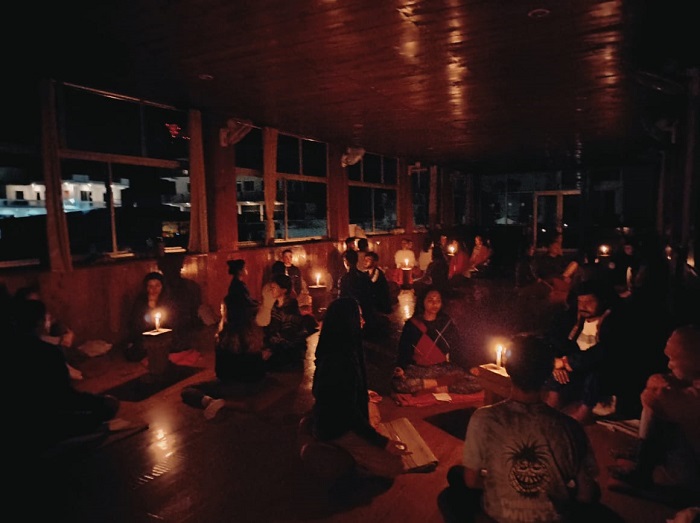 Yoga students in a candlelit meditation session, creating a peaceful and mindful atmosphere for inner reflection