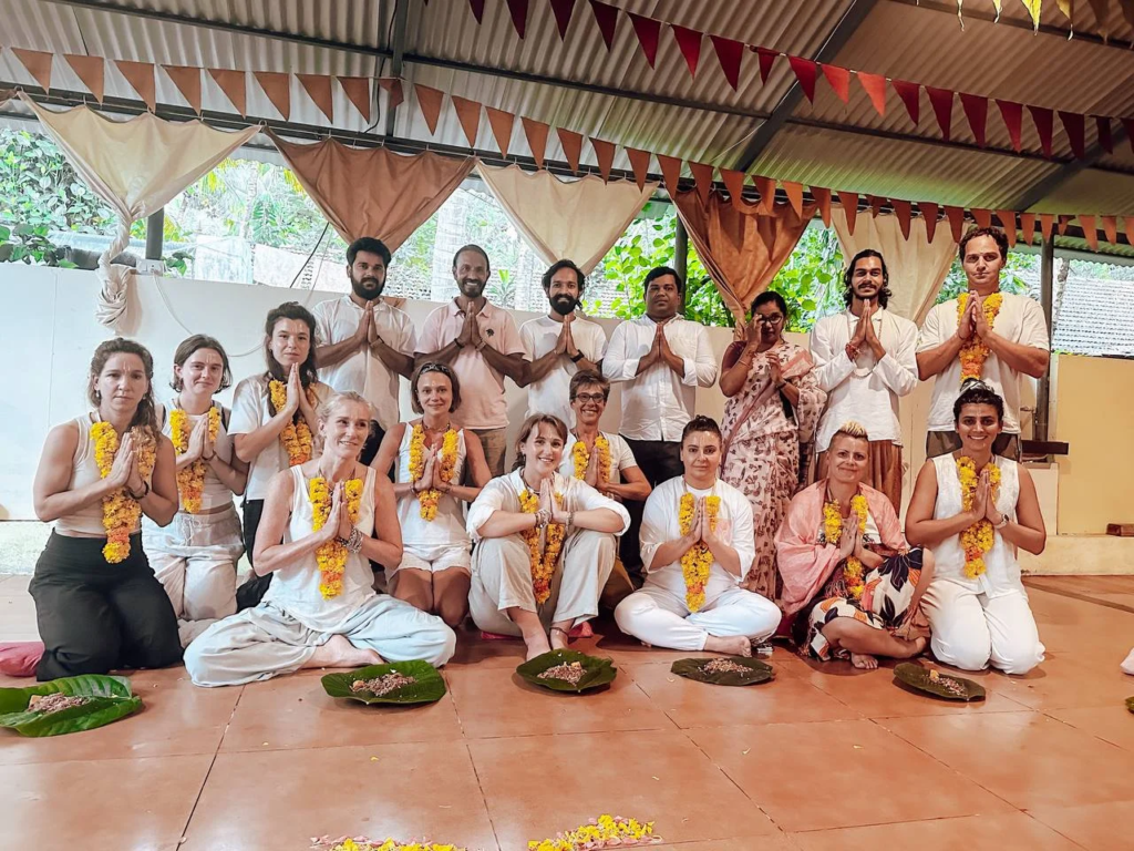 Group of people dressed in white, sitting and standing in a spiritual ceremony