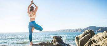 Women Practicing Yoga on a Beach Women Practicing Yoga on a Beach