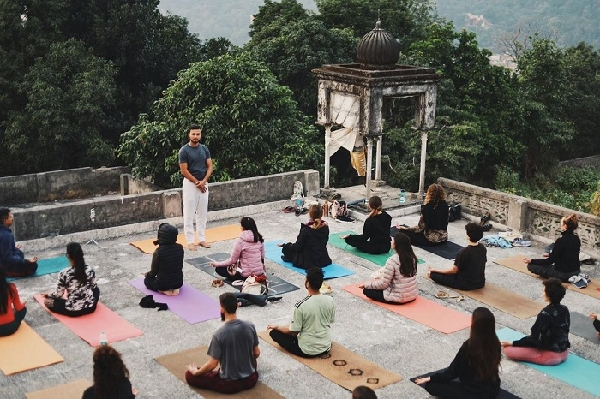 Yoga instructor leading a meditation session Yoga instructor leading a meditation session on an open rooftop with students