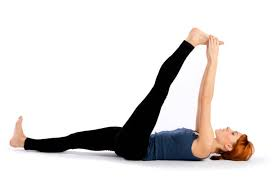 Woman Practicing Supta Padangusthasana (Reclining Hand-to-Big-Toe Pose) Yoga Woman performing Supta Padangusthasana (Reclining Hand-to-Big-Toe Pose) yoga