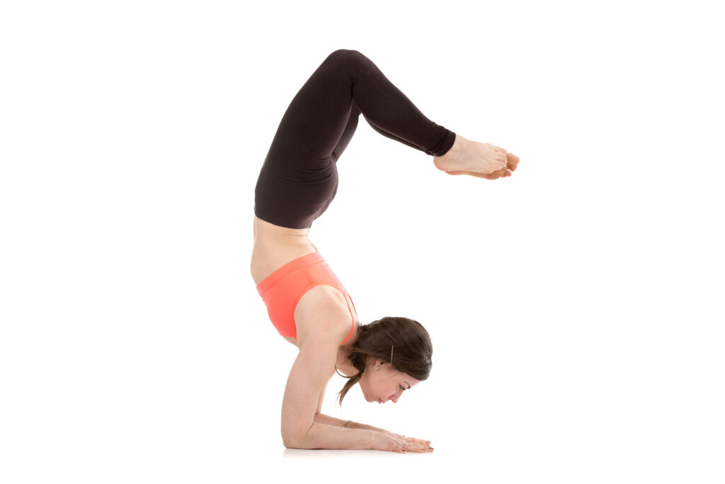 Woman Performing Scorpion Pose (Vrschikasana)