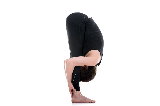 Women Performing Uttanasana also known as Standing Forward Bend Pose